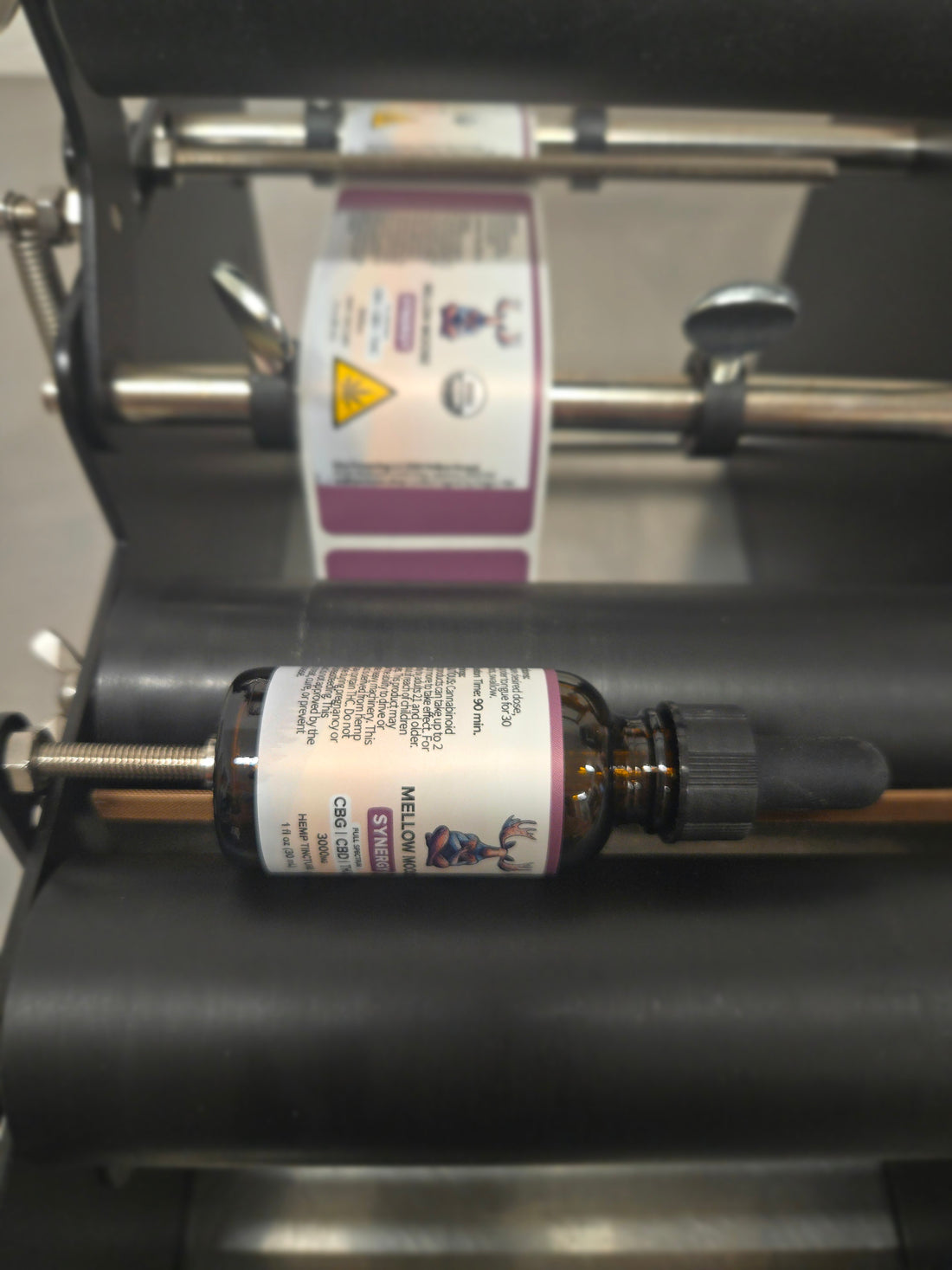 A Mellow Moose tincture bottle being labeled on the farm.