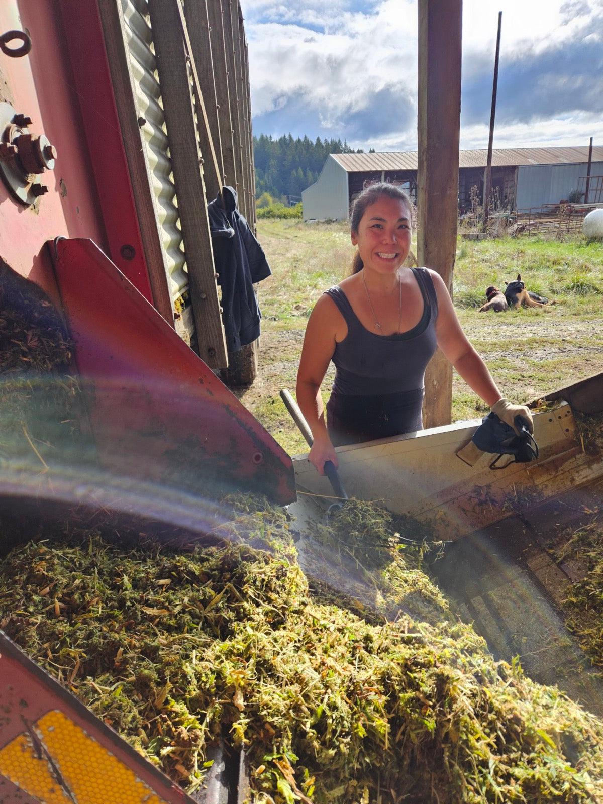 Vina smiling while working beside the hemp dryer.